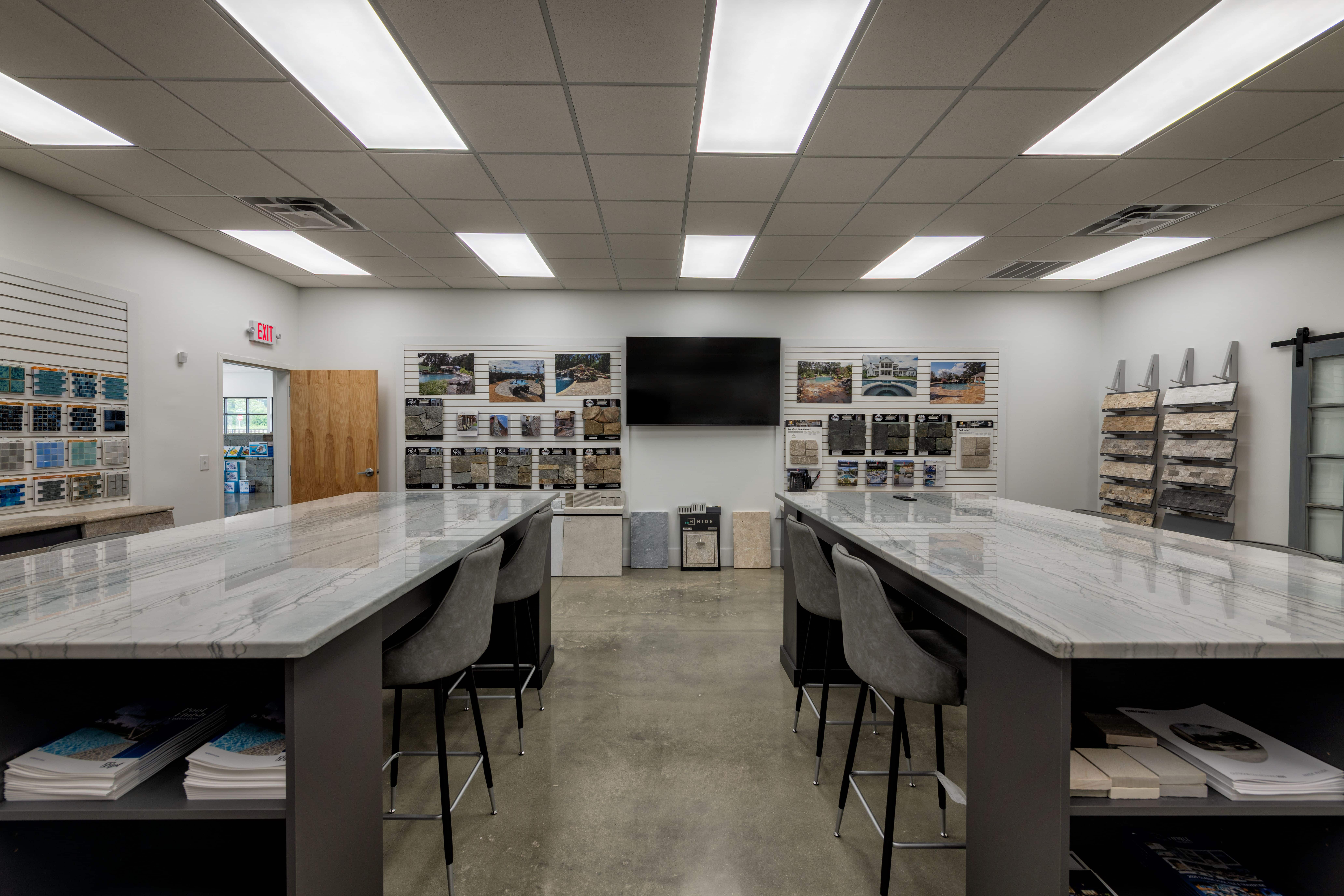 B & B Pools design showroom with marble counters, tile samples, and project displays