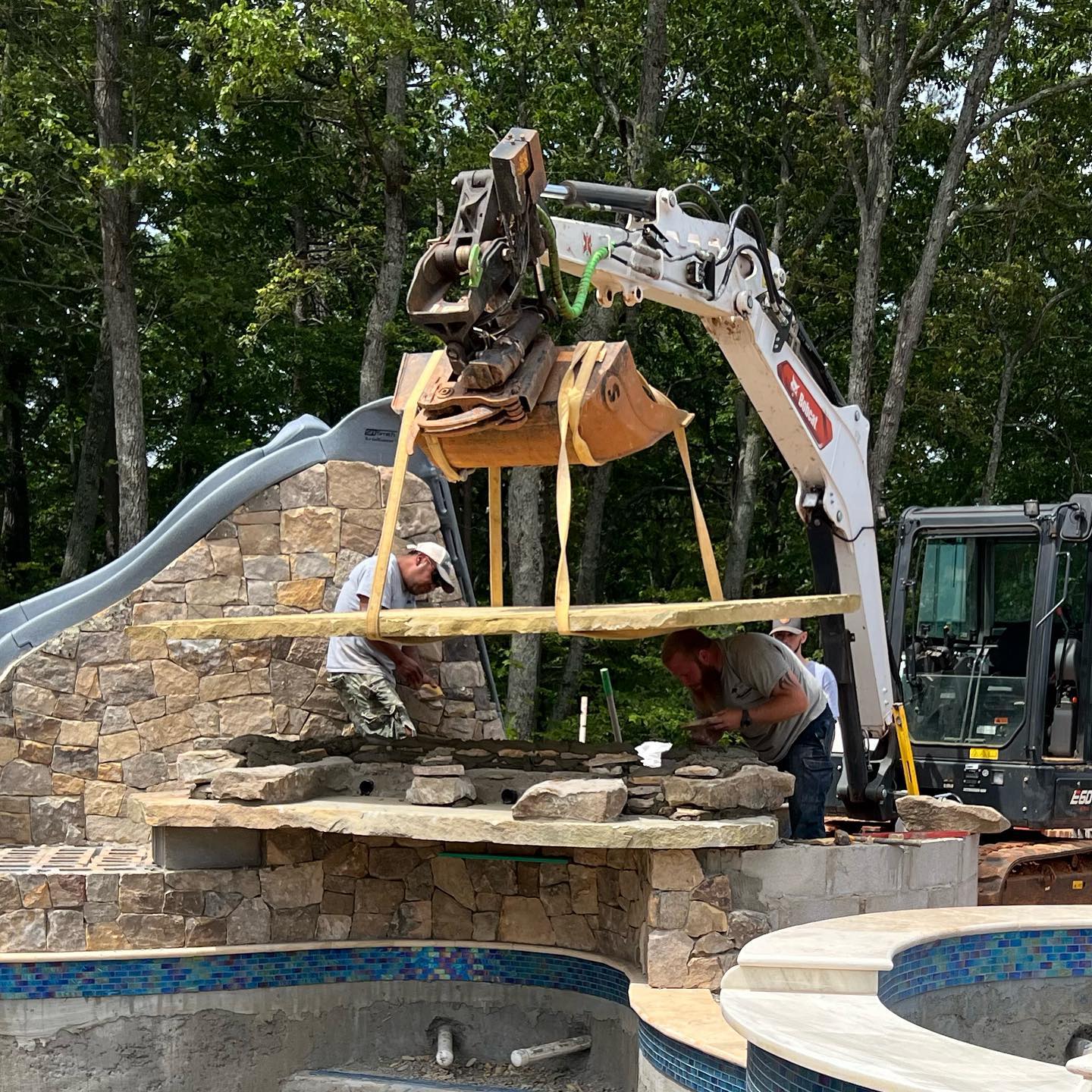 Team installing stone grotto and slide feature