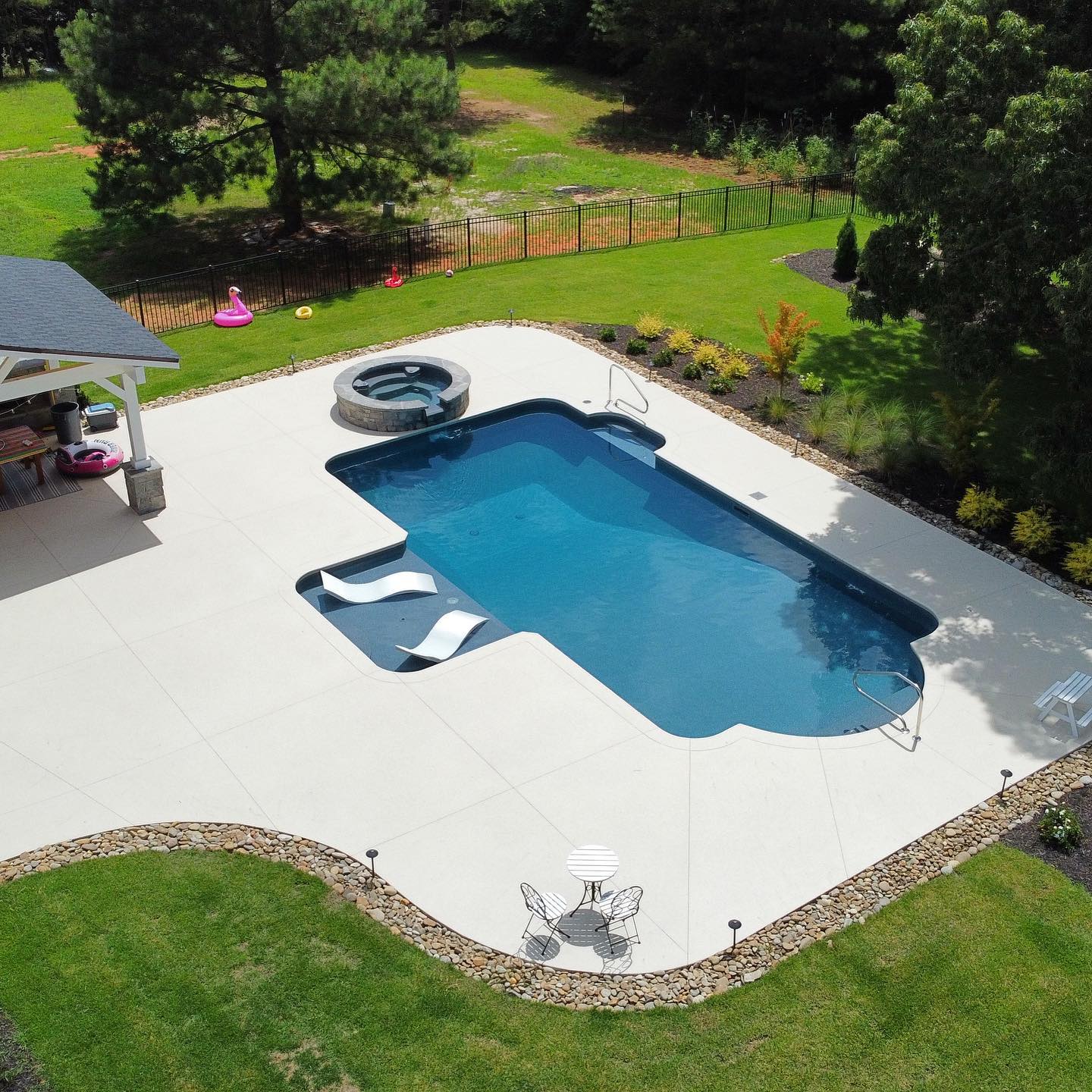 Aerial view of rectangular vinyl pool with round spa