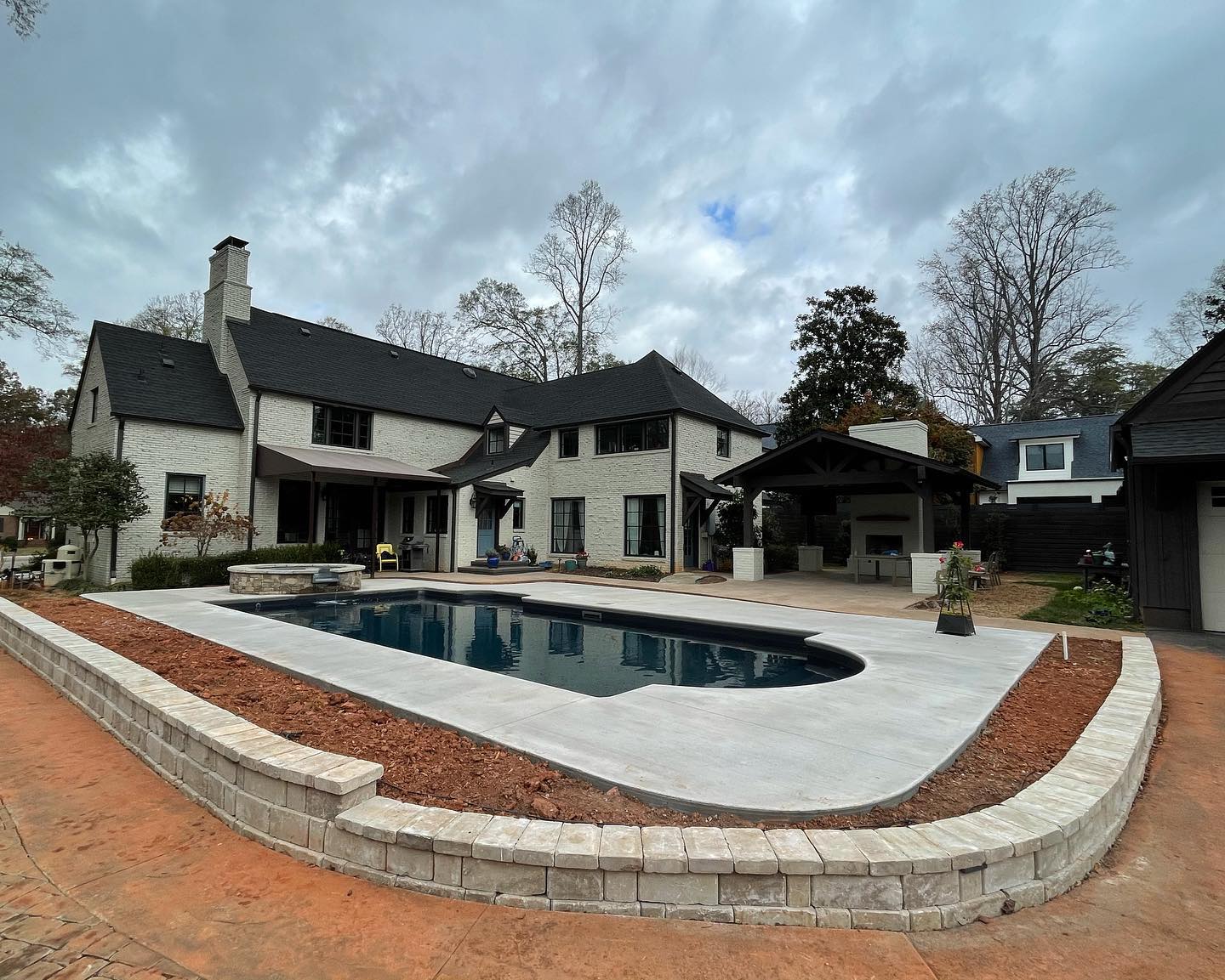 Vinyl pool with raised retaining wall and outdoor kitchen