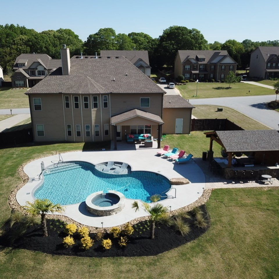 Aerial view of freeform vinyl pool with spa and outdoor kitchen
