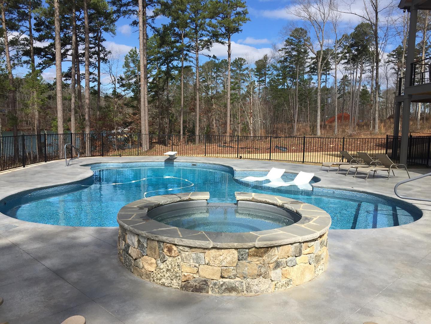 Freeform vinyl pool with raised stone spa