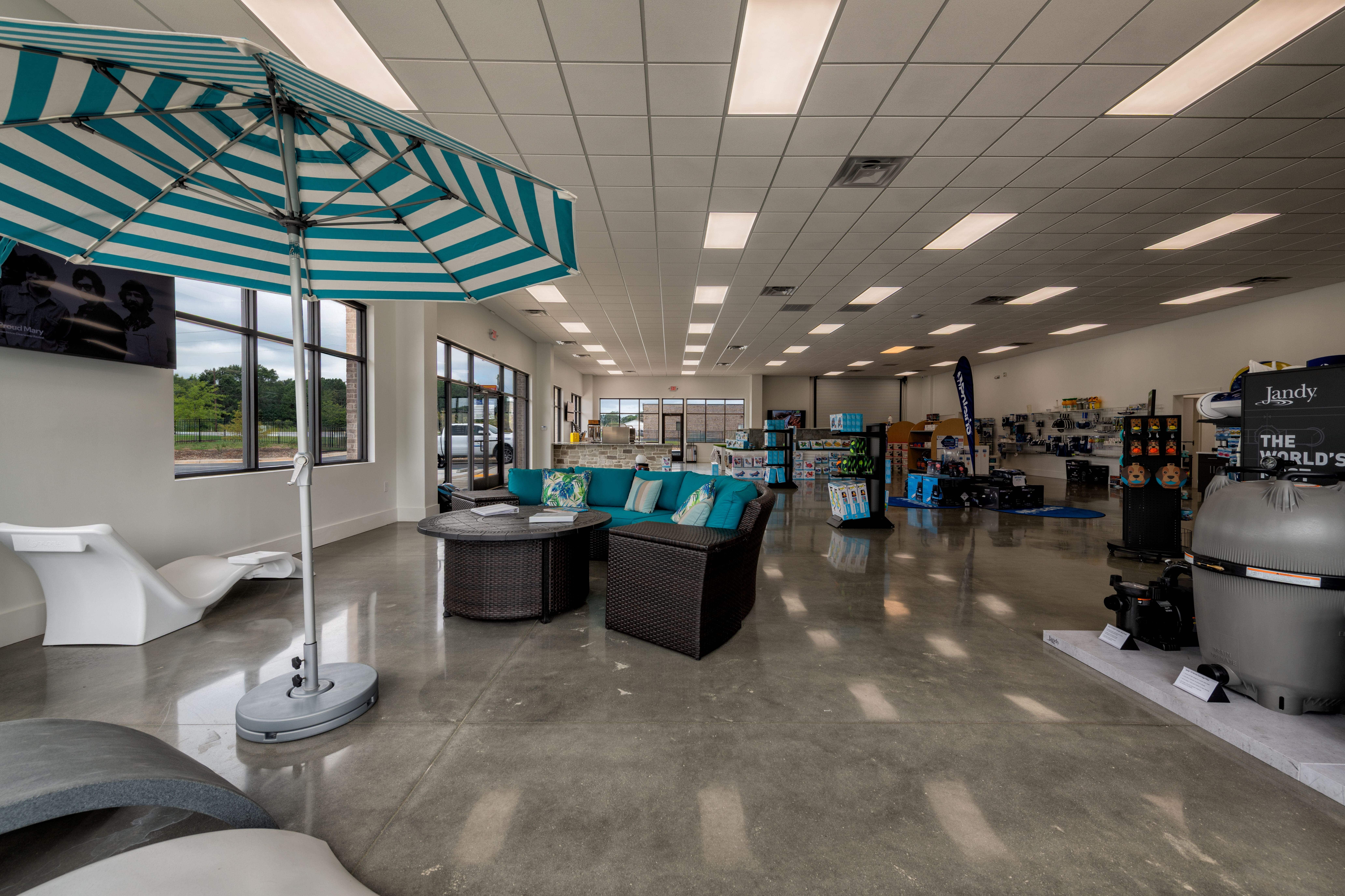 B & B Pools retail showroom with outdoor furniture, umbrellas, and pool equipment